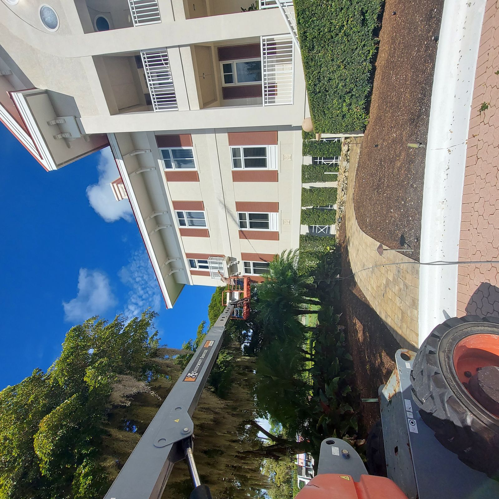 Boom lift pressure washing multi-story residential building — SW Florida
